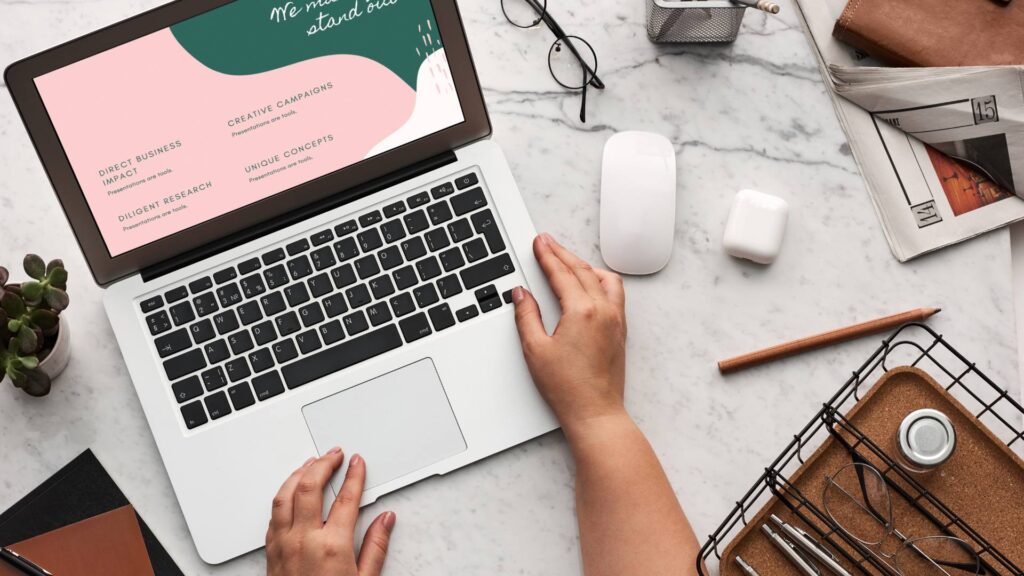 A person sits at their marble desk on a laptop with a digital marketing strategy pulled up on the computer.