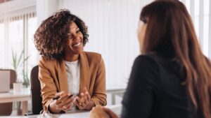 A brand consultant happily chats with a prospective client.