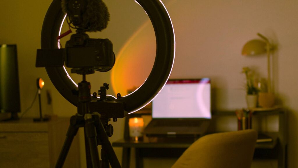 A content creation package is displayed, with a camera and tripod displayed with beautiful sunset lighting against a desk.